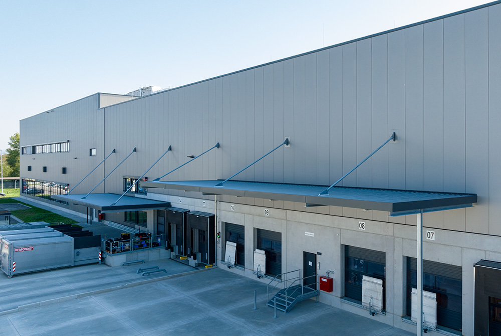 Drohnenaufnahme einer modernen Lagerhalle für den Logistikkunden Ixocon, geplant und realisiert nach hohen Anforderungen an effiziente Logistikprozesse.